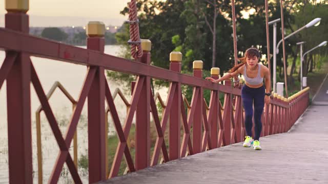 亚洲年轻健康的运动女人在公园里跑步和慢跑在锻炼期间感觉不舒服。这个女孩感到肚子痛。由于胃痛，她停止了运动。疾病和保健概念。
