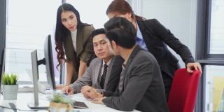 亚洲年轻的商业人士在办公室开会讨论。男人和女人有交流头脑风暴和共同工作的项目作为团队。现代同事的企业