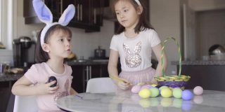 两个女孩在现代厨房里给复活节彩蛋上色