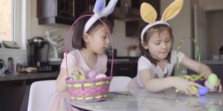 两个女孩在现代厨房里给复活节彩蛋上色