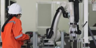 当工程师编程时，机器人的手臂在方向上移动。