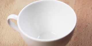 一个茶包掉进了一个空的白色瓷杯里
