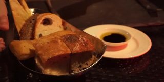 手蘸新鲜出炉的面包在橄榄油和醋意大利餐厅