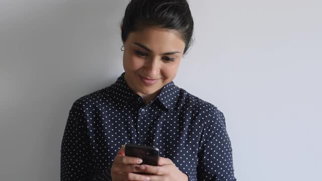 沉迷于科技的年轻印度裔女性使用手机应用。