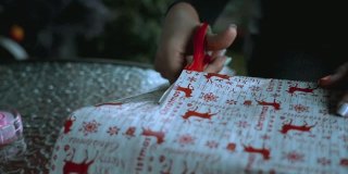 亚洲妇女的手与剪刀包装纸
