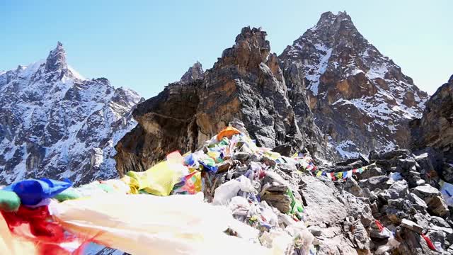 在尼泊尔喜马拉雅山脉中，珠穆朗玛峰地区的莲若拉山口(Renjo La Pass)顶上，五颜六色的佛教经幡在强风中飘扬。