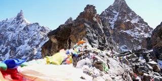 在尼泊尔喜马拉雅山脉中，珠穆朗玛峰地区的莲若拉山口(Renjo La Pass)顶上，五颜六色的佛教经幡在强风中飘扬。