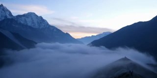 在时间的推移中，美丽的山谷在定伯切附近的全景，昆布，尼泊尔在喜马拉雅山与雄伟的雪山后日落和云移动回山谷。