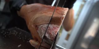 一个厨师正在用电锯锯生冻肉