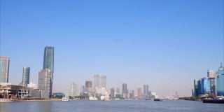 美丽的上海城市景观，蓝天背景，黄浦江上的货船，4k慢镜头，宽镜头b卷拍摄视频。