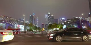 汽车在镜头前分散开来，背景是广州的摩天大楼。大城市的夜生活