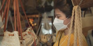 成年成熟的亚洲女性执拗口罩防毒购物手挑传统老藤包产品旅游理念