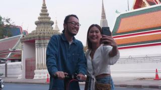 潮男美女在旅游著名景点(卧佛寺)时用手机搜索信息;曼谷泰国视频素材模板下载