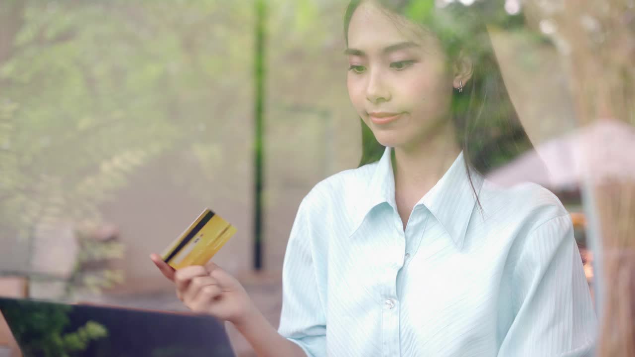 年轻女子用智能手机刷卡购物