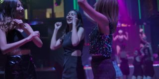 快乐的时间。一群年轻的亚洲女子在夜总会跳舞。