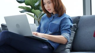 使用笔记本电脑在家工作的亚洲女性社交距离covid-19隔离冠状病毒。妇女使用笔记本电脑在家在线开会，在线学习到办公室团队会议通过电话会议视频素材模板下载