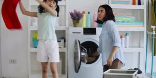 亚洲母亲和女儿在打扫或清洗时玩耍。