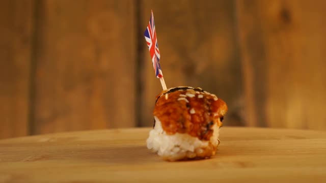 寿司配上鱼、米饭、海藻和英国小旗放在上面，在木制的转盘上旋转。