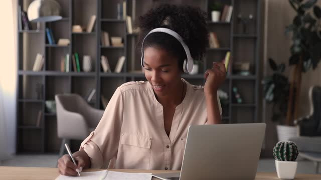混血女性戴着耳机在线收听在线学习音频课程