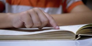 孩子用手指触摸书页，阅读速度很快。在家远程阅读