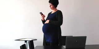 怀孕的自由职业者在工作的时候打电话给她的丈夫，说有好消息。