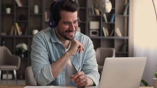 男子戴耳机在线学习与在线家教视频通话