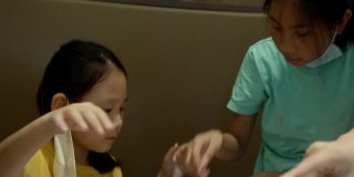 快乐3亚洲女孩与家人一起在餐厅吃素喜烧、涮涮锅或火锅，生活方式理念。