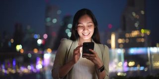 亚洲女商人在城市之夜，社交媒体，手机，短信中使用电话