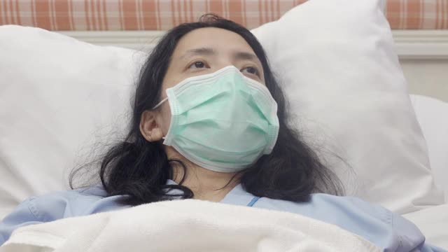 住院妇女病人在家人的支持下躺在床上