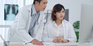 两位医生在医务室的电脑屏幕上分析讨论