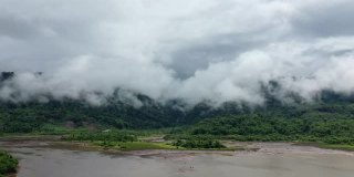 自然组成的森林和绿色山脉混合云塔克，老挝，亚洲，在雨季，无人机在一天的雨和云。
