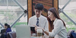 两个亚洲商人在用笔记本电脑聊天