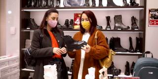 年轻的女性朋友们正在享受他们的冬季购物，寻找一些新的皮靴