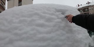 清理挡风玻璃——一名男子正在清理袭击他汽车的大雪，这张照片是用GoPro相机拍摄的