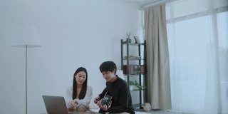 年轻的亚洲夫妇在弹吉他