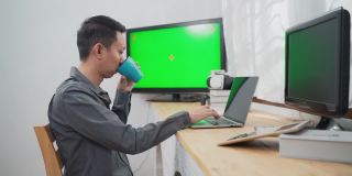 年轻的资讯科技人员使用多台绿屏电脑工作