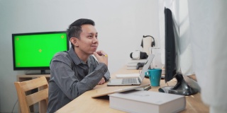 年轻的资讯科技人员使用多台绿屏电脑工作