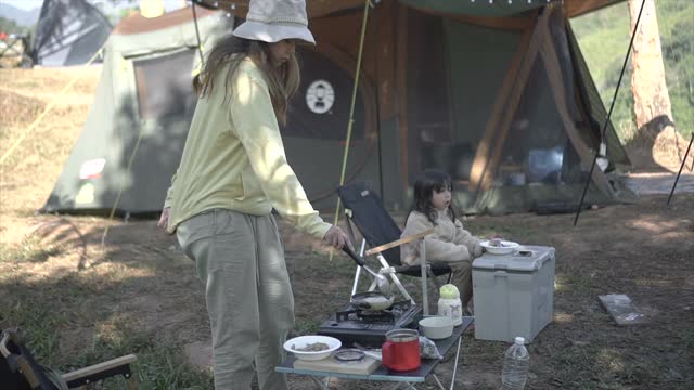 母亲和女儿花周末时间一起露营和做早餐