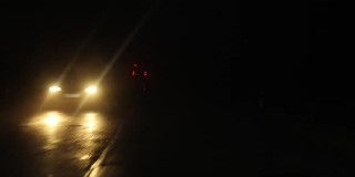 救护车在夜间开着闪烁的灯在长长的道路上运送病人。雾天夜里的乡间小路。有选择性的重点