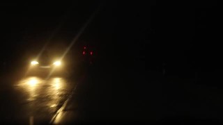 救护车在夜间开着闪烁的灯在长长的道路上运送病人。雾天夜里的乡间小路。有选择性的重点视频素材模板下载