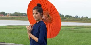 年轻的亚洲妇女穿着泰国风格的传统服装。