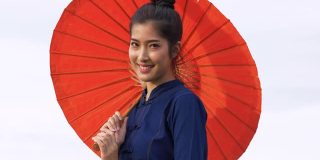 年轻的亚洲妇女穿着泰国风格的传统服装。