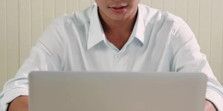 亚洲商人在桌上用笔记本电脑工作。