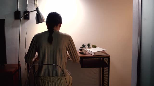 亚洲女性在家庭办公室工作。在电脑前工作。