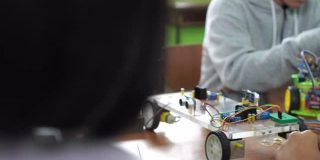 科学和技术课堂中学水平:老师解释如何操作一个机器人程序给孩子们