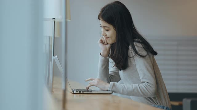 亚洲女学生在图书馆使用笔记本电脑