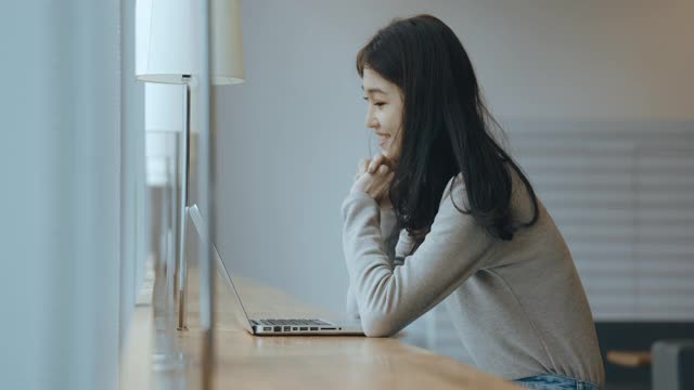 亚洲女学生在图书馆使用笔记本电脑