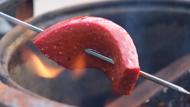 传统的土耳其香肠，SUJUK，放在金属串上，在木火上翻转。