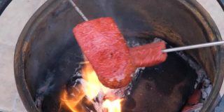 传统的土耳其香肠，SUJUK，放在金属串上，在木火上翻转。