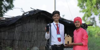 年轻的印度银行职员向农民展示手机屏幕